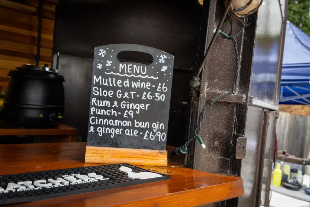 A chalkboard menu of mulled wine and festive drinks at the outdoor bar at the Ashdon Christmas Market